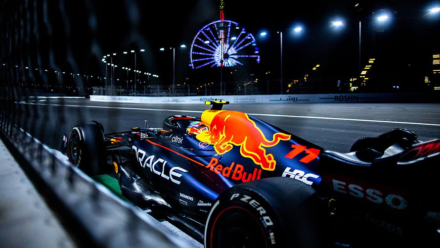 Oracle Red Bull Racing Formula 1 car on the night track with a lit Ferris wheel in the background HD wallpaper