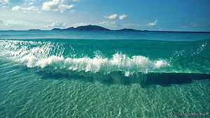 Tropical Beach Wave Breaking in Turquoise Water with Distant Island Horizon HD wallpaper