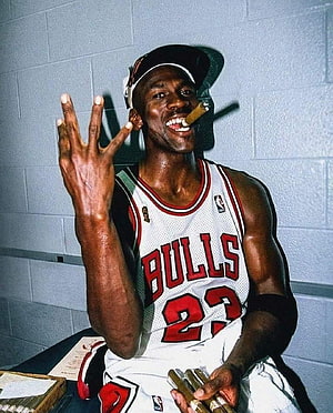 Michael Jordan in Chicago Bulls jersey holding cigar in locker room HD phone wallpaper