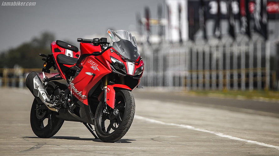 Red TVS Apache RR 310 Sport Motorcycle Parked on a Race Track HD wallpaper