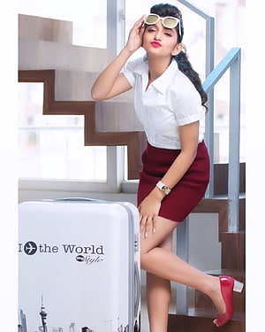 Sreeleela in white shirt and maroon skirt posing with travel suitcase on stairs HD phone wallpaper