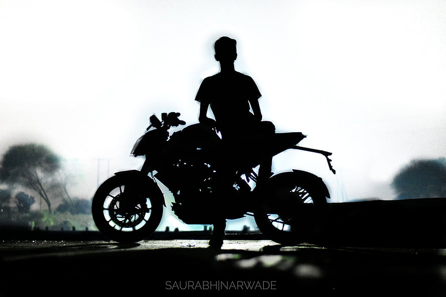 Silhouette of a Rider on a Sport Motorcycle Against a Bright Hazy Sky HD wallpaper