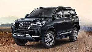 Black Toyota Fortuner SUV on a dusty desert road with mountain backdrop HD wallpaper
