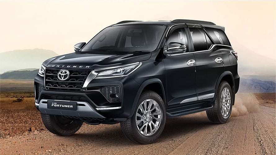 Black Toyota Fortuner SUV on a dusty desert road with mountain backdrop HD wallpaper