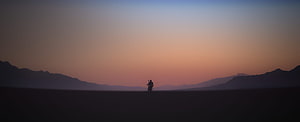 The Mandalorian Silhouette Riding Through Vast Desert at Sunset HD wallpaper