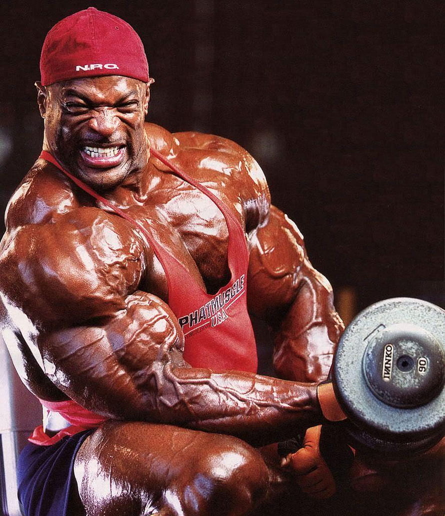 Ronnie Coleman performing intense dumbbell curls in red tank top and cap HD phone wallpaper