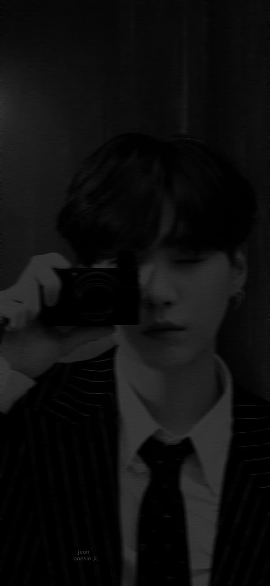 Min Yoongi in a dark pinstripe suit holding a compact camera in a moody black and white portrait HD phone wallpaper
