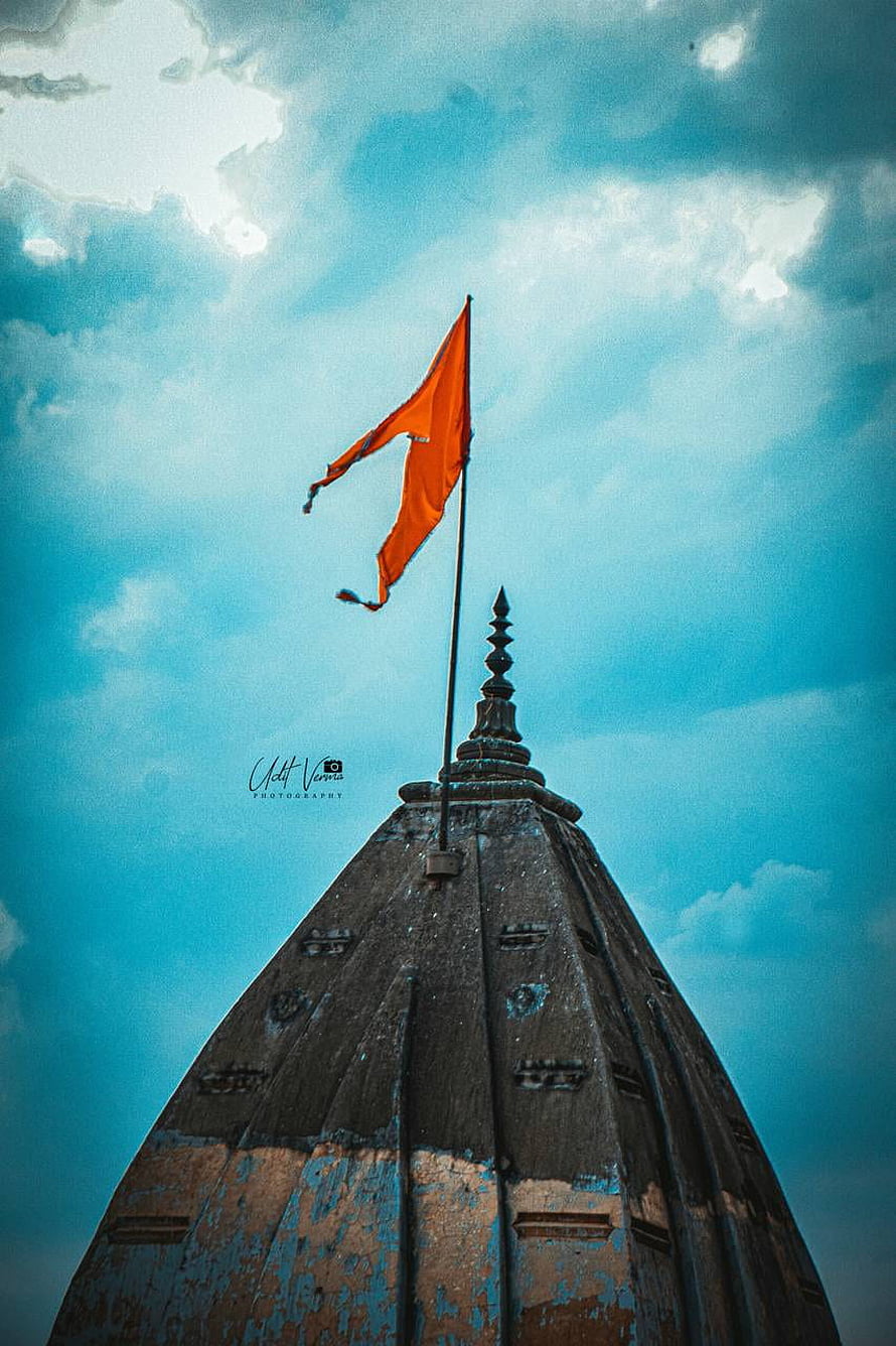 Saffron Bhagwa Flag Flying Above Ancient Temple Spire Against Dramatic Sky HD phone wallpaper