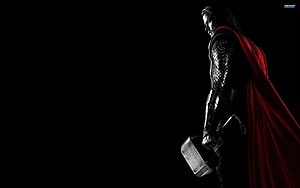 Thor in Dark Armor Holding Mjolnir with Flowing Red Cape Against Black Background HD wallpaper
