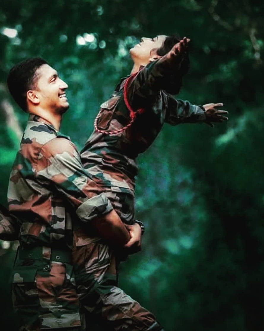 Indian Army couple in camouflage uniforms sharing a joyful moment in a lush green forest HD phone wallpaper