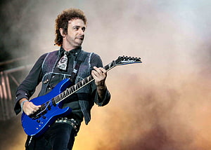 Gustavo Cerati performing live on stage with a blue electric guitar HD wallpaper