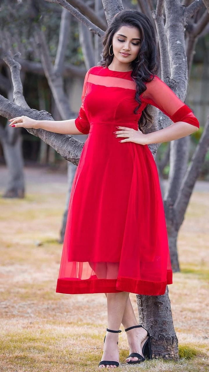 Anupama Parameswaran in a flowing red chiffon dress posing outdoors by a tree HD phone wallpaper