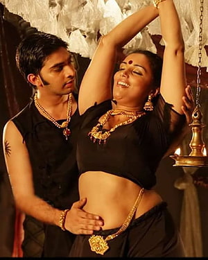 Shweta Menon in a dramatic dance scene wearing traditional black attire and gold jewelry HD phone wallpaper