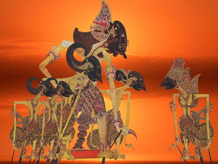 Traditional Indonesian Wayang Kulit Puppet Silhouettes Against Vibrant Orange Sunset Sky HD wallpaper