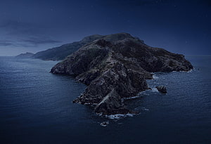 Misty Coastal Island at Night with Starry Sky and Calm Ocean Waters HD wallpaper