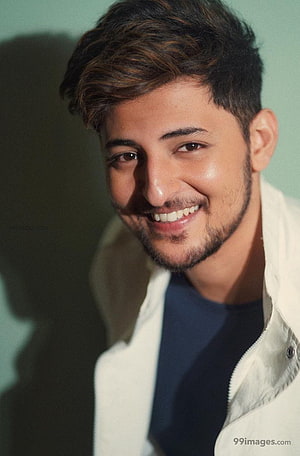 Darshan Raval smiling portrait in white jacket against a soft green background HD phone wallpaper