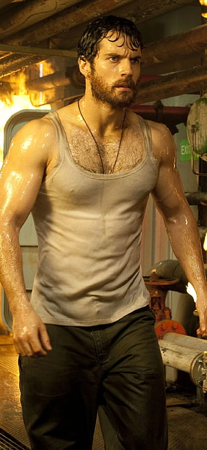 Henry Cavill as Clark Kent in a gritty industrial setting wearing a soaked white tank top HD phone wallpaper