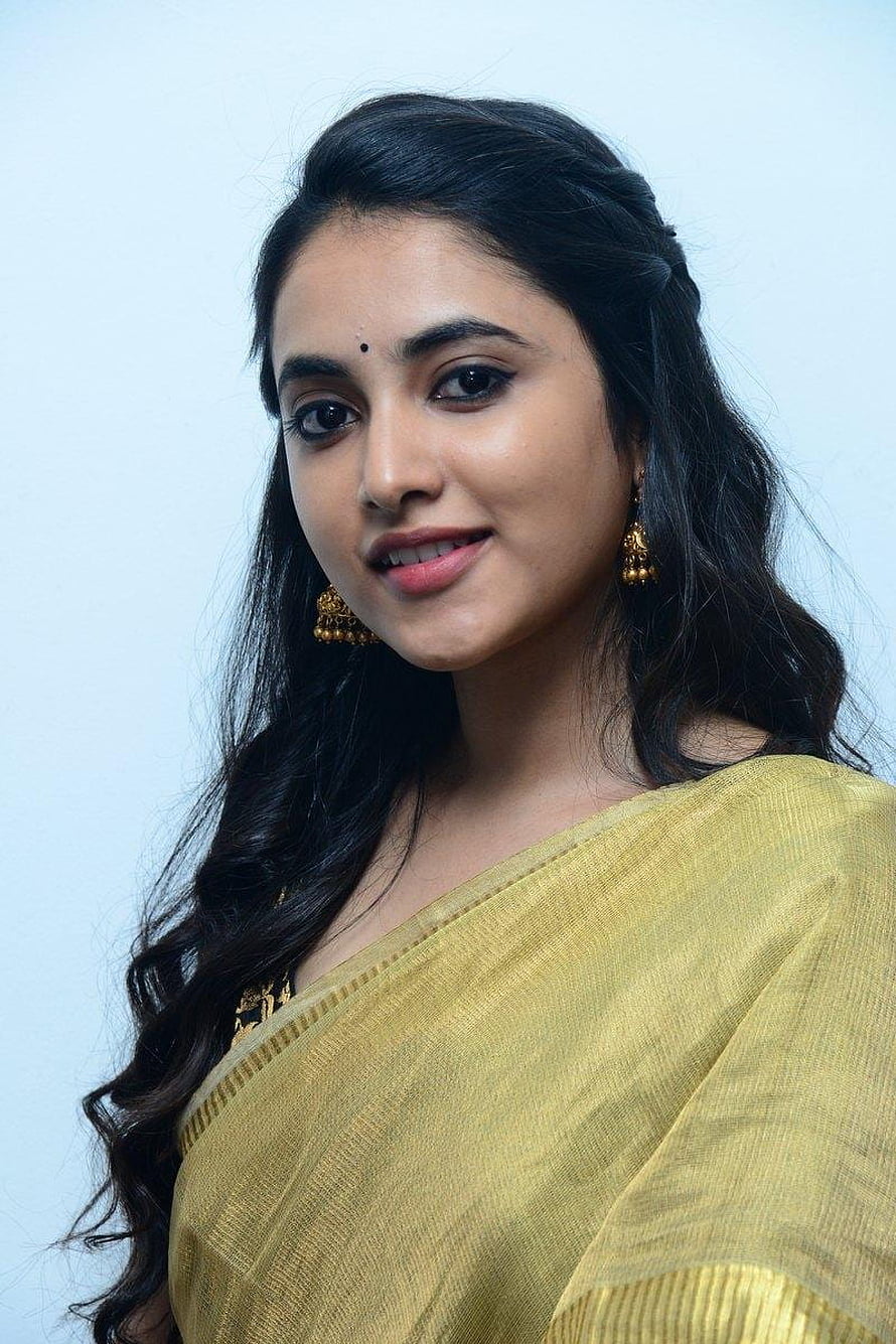 Priyanka Arul Mohan in a yellow saree with gold jhumka earrings and long wavy hair HD phone wallpaper