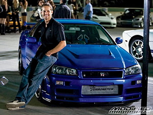 Paul Walker Leaning Against Blue Nissan Skyline GT-R at Nighttime Car Meet HD wallpaper