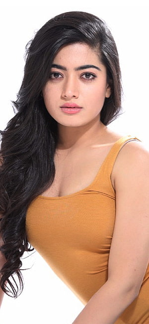 Rashmika Mandanna Portrait in Mustard Yellow Tank Top with Long Wavy Hair HD phone wallpaper