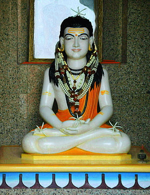 Gorakhnath statue in meditative lotus pose with orange dhoti and sacred bead necklaces HD phone wallpaper