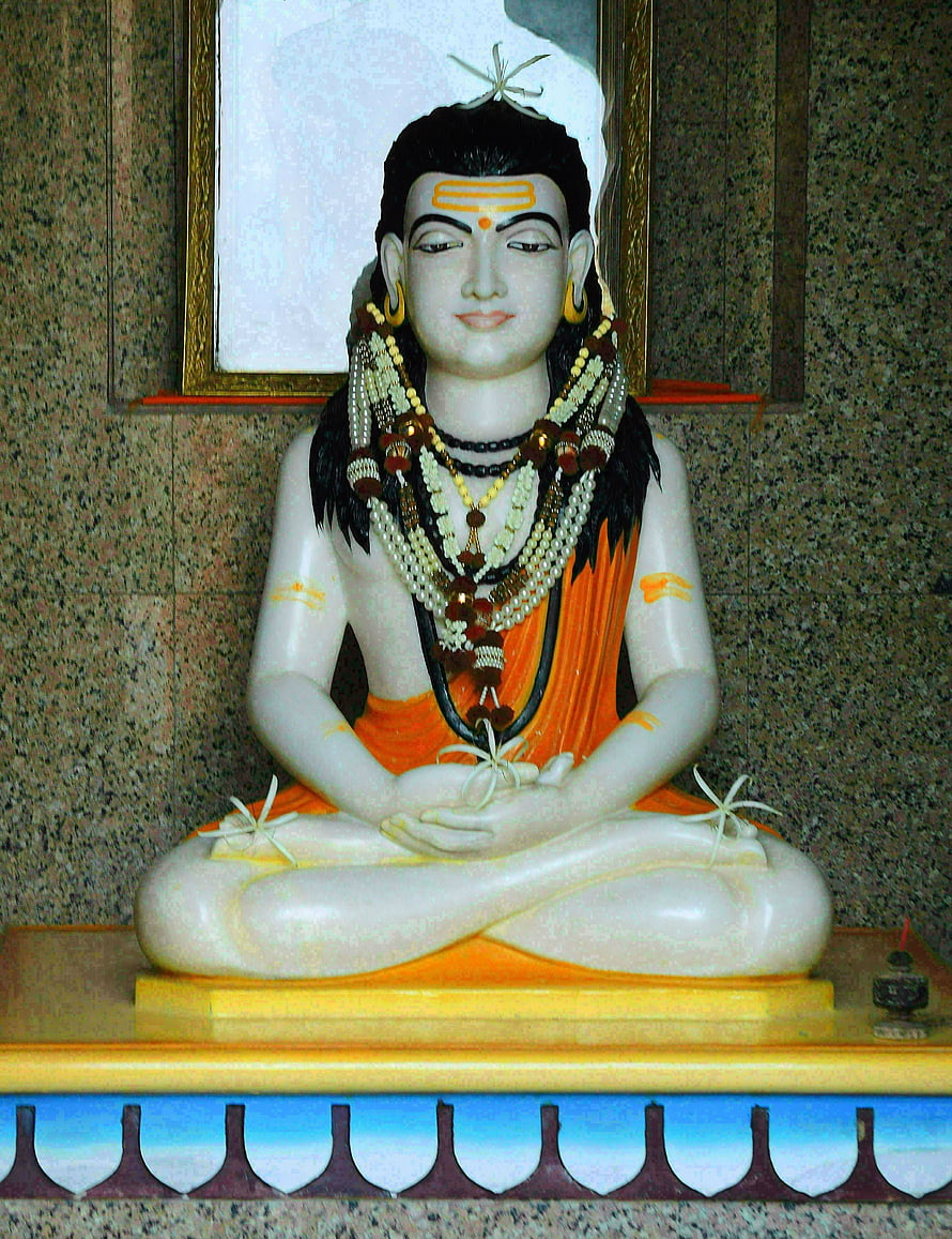 Gorakhnath statue in meditative lotus pose with orange dhoti and sacred bead necklaces HD phone wallpaper