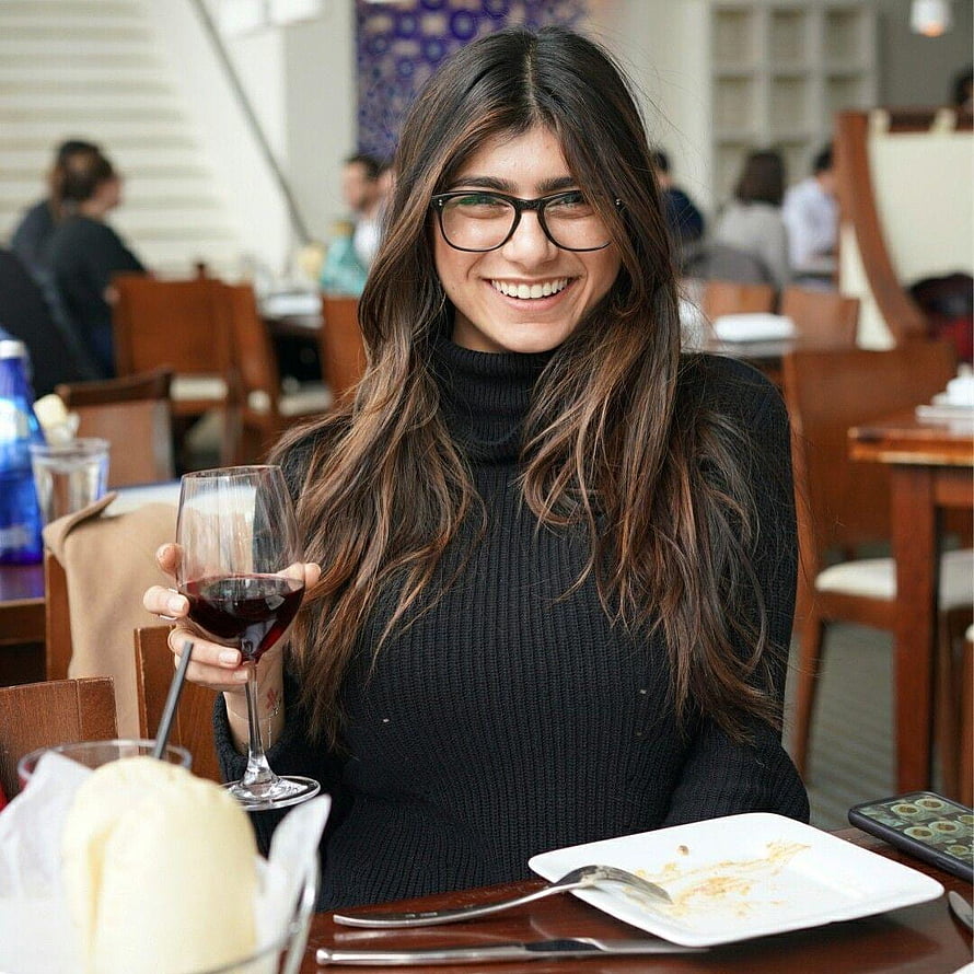 Mia Khalifa smiling at a restaurant table holding a glass of red wine HD phone wallpaper