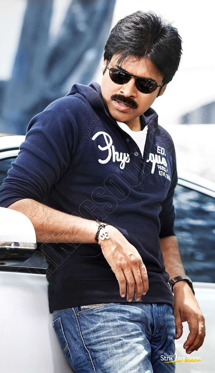Pawan Kalyan in navy hoodie and sunglasses leaning against a white car HD phone wallpaper