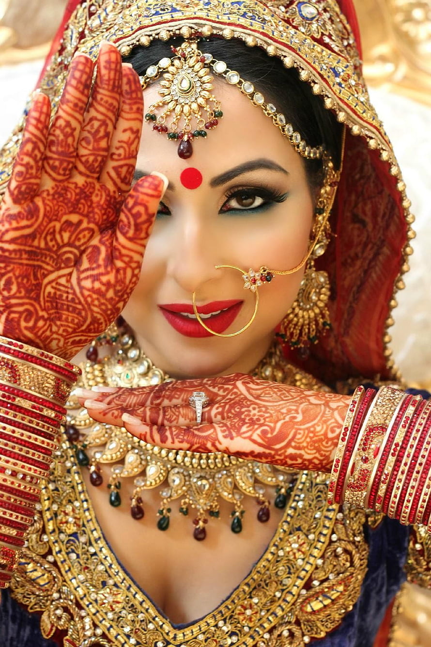 Indian Bride in Traditional Red and Gold Attire with Intricate Henna and Jewelry HD phone wallpaper