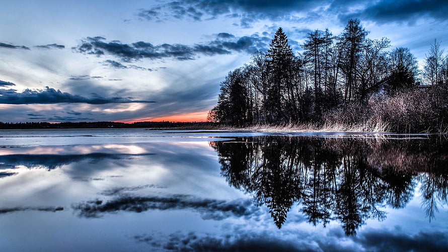 Serene Winter Lake at Dusk with Pine Trees and Dramatic Cloud Reflections HD wallpaper