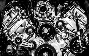 Black and White Close-Up of a Complex Car Engine with Pulleys and Belts HD wallpaper