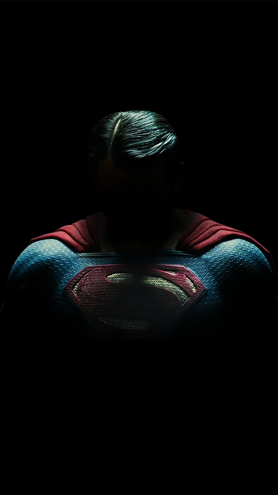 Superman in Dark Cinematic Lighting with Glowing S Logo and Red Cape HD phone wallpaper