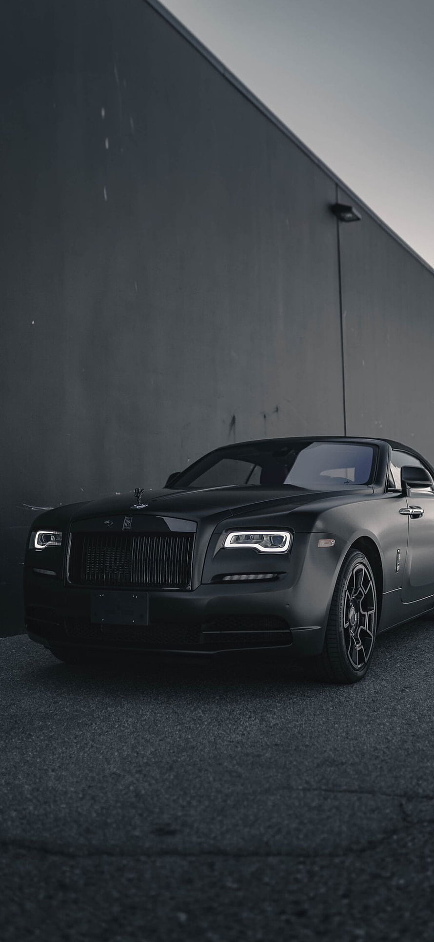Matte Black Rolls-Royce Ghost Parked Against Industrial Concrete Wall HD phone wallpaper