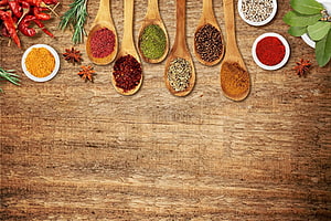 Assorted Spices and Herbs Arranged on Wooden Spoons Over Rustic Table HD wallpaper
