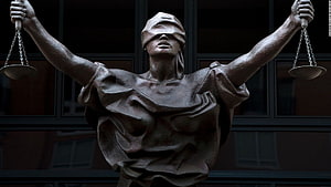 Blindfolded Lady Justice Statue Holding Scales of Law in Front of Court Building HD wallpaper