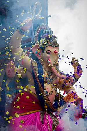 Chintamani Ganpati Murti Adorned in Vibrant Silks with Confetti and Incense Smoke HD phone wallpaper