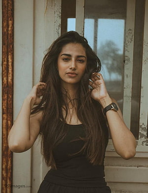 Meenakshi Chaudhary Portrait in Black Top with Long Wavy Hair HD phone wallpaper