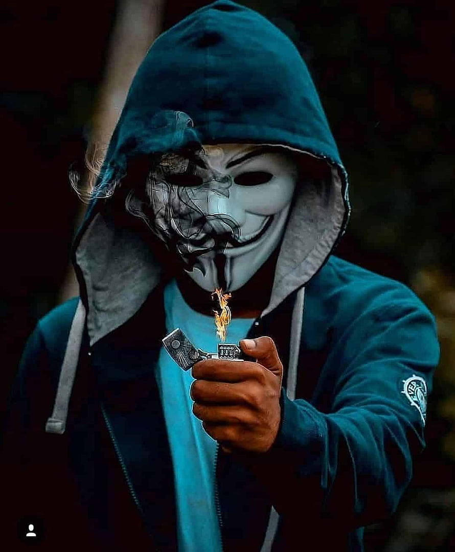 Guy in Teal Hoodie Wearing Guy Fawkes Mask Holding a Lit Lighter with Smoke HD phone wallpaper