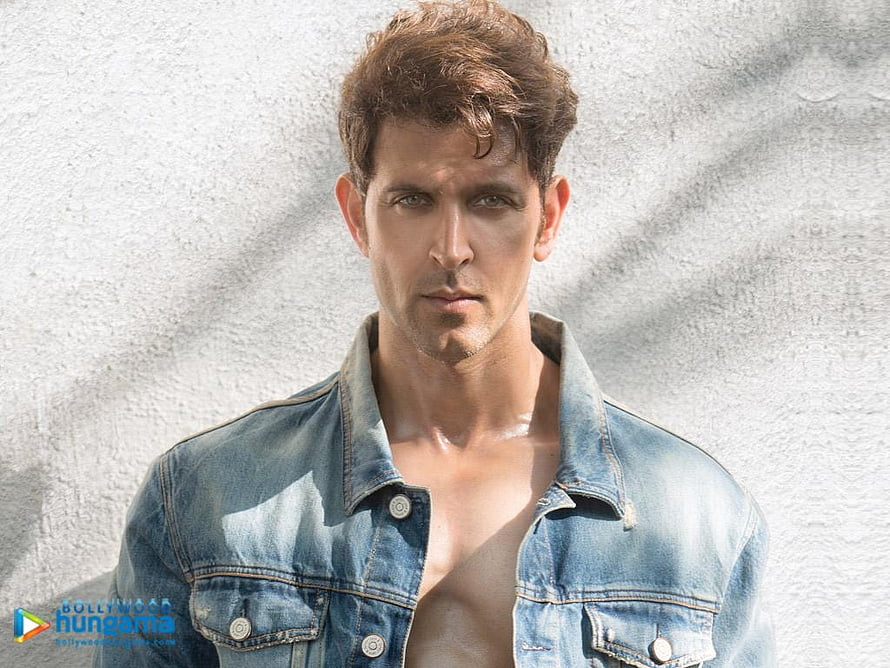 Hrithik Roshan in an open denim jacket against a textured white wall HD wallpaper
