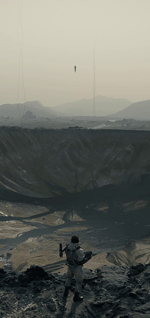 Death Stranding Character Overlooking Vast Crater Landscape in Desolate Sci-Fi World HD phone wallpaper