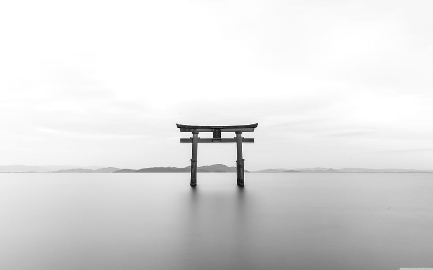 Minimalist Black and White Torii Gate Standing in Calm Water with Distant Hills HD wallpaper