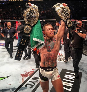 Conor McGregor Celebrates UFC Victory Holding Championship Belts and Irish Flag in the Octagon HD phone wallpaper