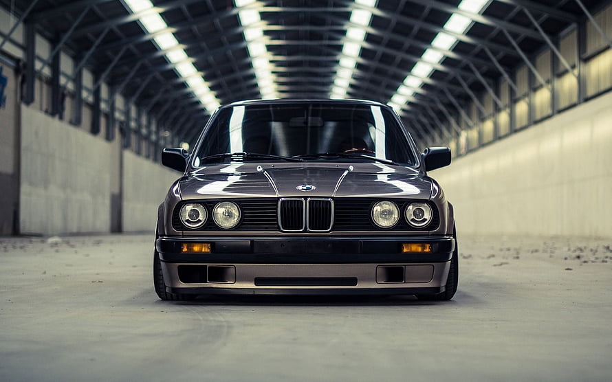 Front View of a Classic BMW E30 325is Sedan Parked in an Industrial Warehouse HD wallpaper