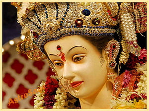 Goddess Durga Face Close-Up with Ornate Crown, Jewels, and Floral Garland HD wallpaper