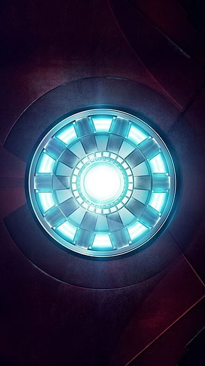 Glowing Iron Man Arc Reactor Core with Cyan Energy Rings and Dark Metallic Housing HD phone wallpaper