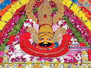 Shri Khatu Shyam Ji adorned in vibrant floral garlands and ornate golden crown HD wallpaper