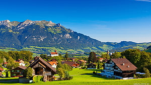 Swiss Alpine Village with Traditional Chalets and Mountain Backdrop HD wallpaper