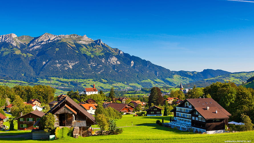 Swiss Alpine Village with Traditional Chalets and Mountain Backdrop HD wallpaper