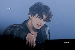 BTS Jungkook in Black Leather Jacket at Concert with Blue Stage Lighting HD wallpaper