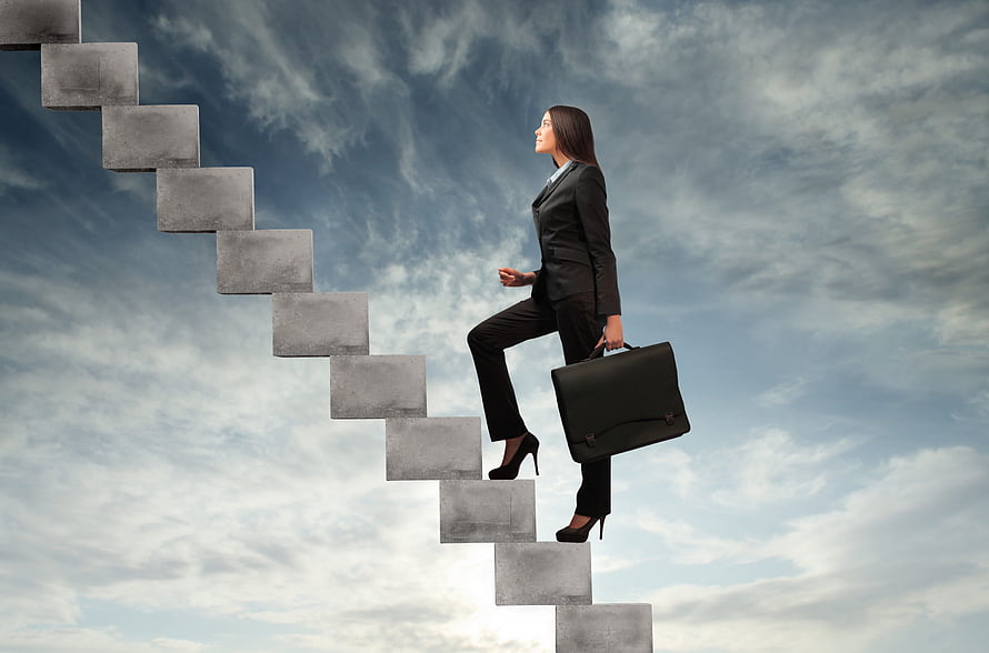 Businesswoman in a black suit ascending floating concrete stairs against a cloudy sky HD wallpaper